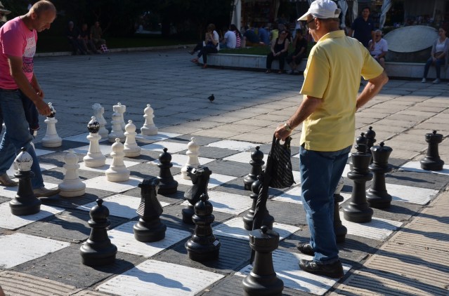 Men playing chess on a giant board