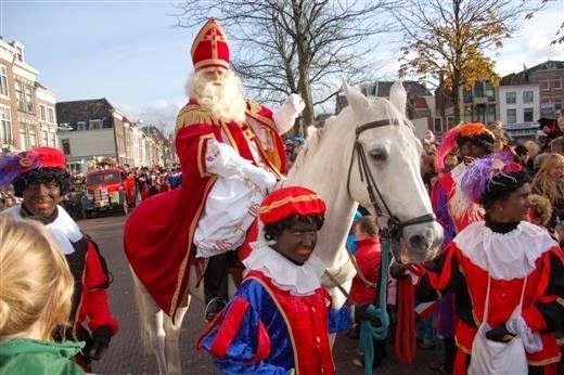 St Nicholas ( Sinterklaas) riding on a horse surrounded by his helpers (Picture courtesy of Phlegmish and Walloony)