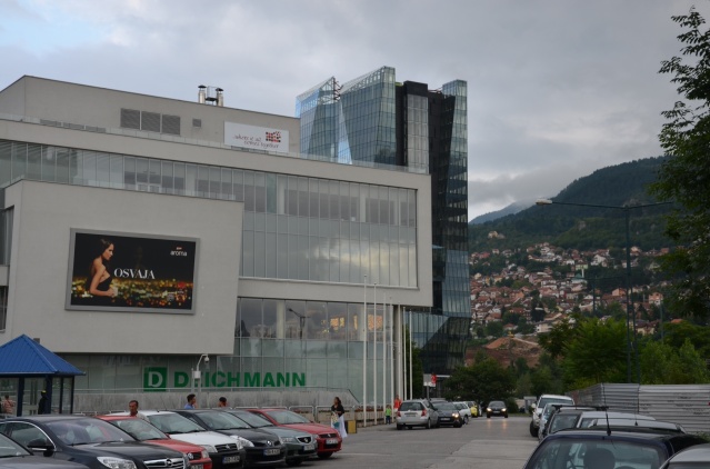 In the foreground, a mega mall, in the background rolling hills at Sarajevo, Bosnia and Herzegovina.