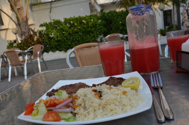 A healthy lunch served at the hotel: Rice with raisins, steak and salad, washed down with fresh melon juice.