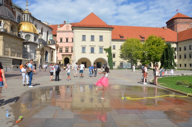 My daughter splashes around in the courtyard of Wawel castle